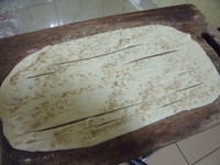 桌上撒一些麵粉,將劑子擀成長方形後,放到砧板上,用刀子每0.5~08公分劃一刀,抹上豬油,再抹塩,撒上胡椒粉。